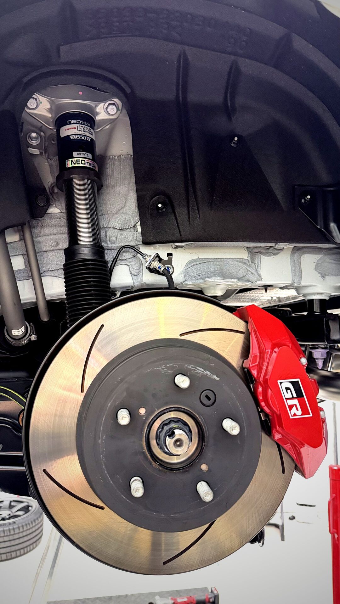 NeoTech coilover ติดตั้งบน GR Yaris — แสดงดิสเบรค GR สีแดงและช่วงล่างหน้า