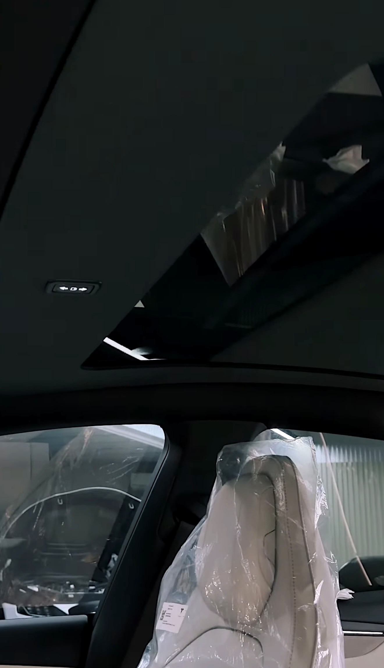 ม่านหลังคาไฟฟ้า Tesla เปิดอยู่ เห็นสวิตช์ควบคุมบนเพดานรถ